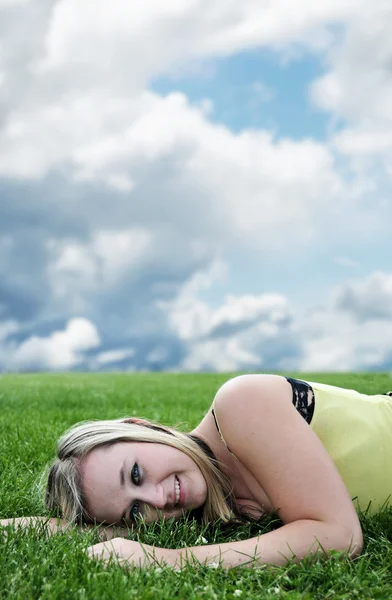 Beautiful blond young girl laying in grass — Stock Photo, Image