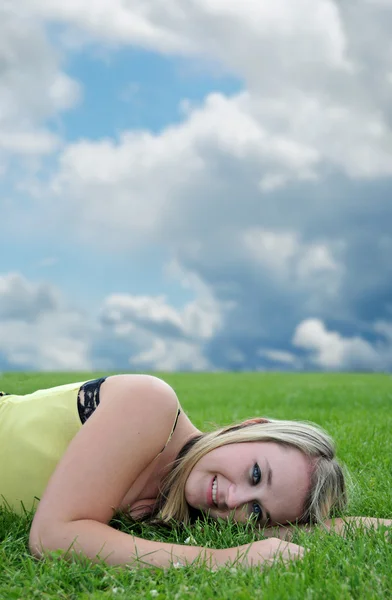 美しい金髪白い白人アダルト 代少女 カメラに笑顔緑の芝生フィールドに敷設のクローズ アップ — ストック写真