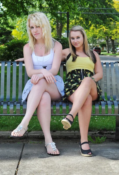 坐在长凳上的两个女孩朋友 — 图库照片