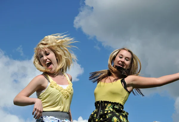 Zwei Mädchen springen in den Himmel — Stockfoto