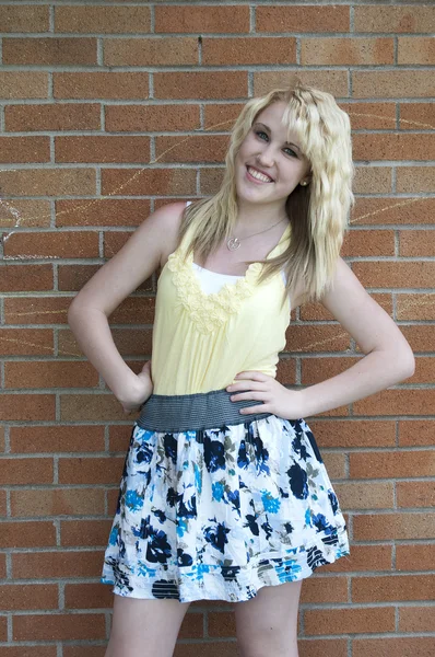 Glückliches Junges Blondes Teenager Mädchen Das Lächelnd Vor Einer Ziegelmauer — Stockfoto