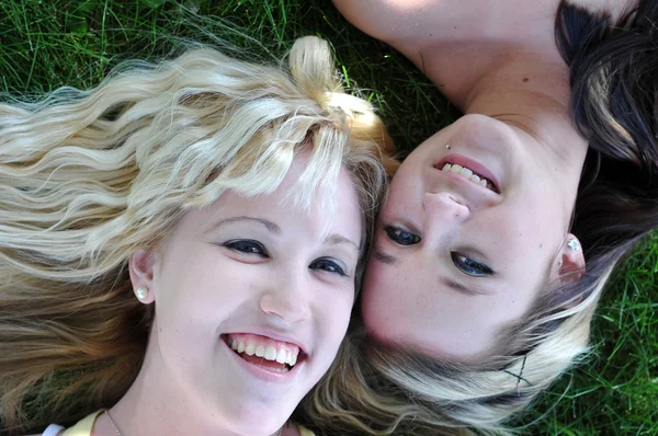 Zwei Freundinnen liegen im Gras — Stockfoto