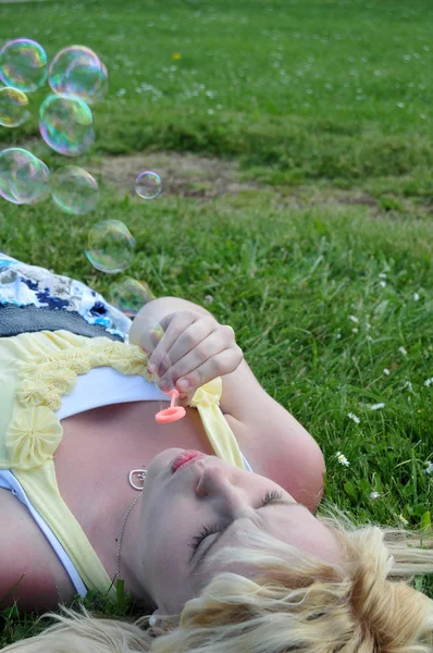 Ragazza soffiando bolle in erba — Foto Stock