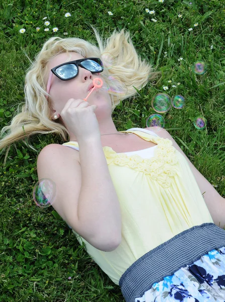 소녀와 그녀의 선글라스에 하늘에 거품을 잔디에 — 스톡 사진