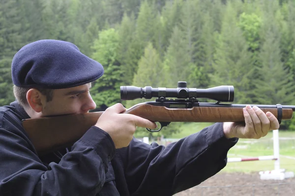 Mann blickt durch Zielfernrohr auf Gewehr — Stockfoto
