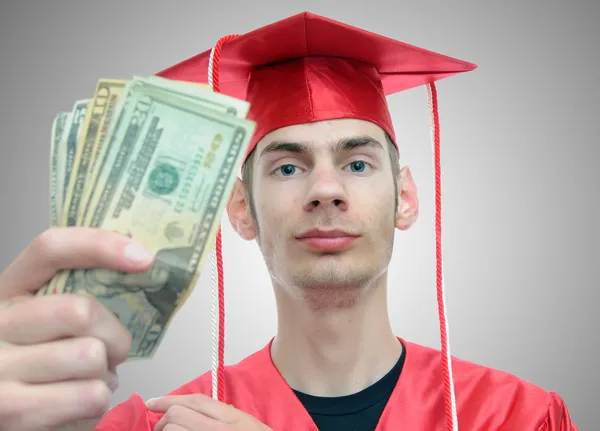 Graduado sosteniendo dinero — Foto de Stock