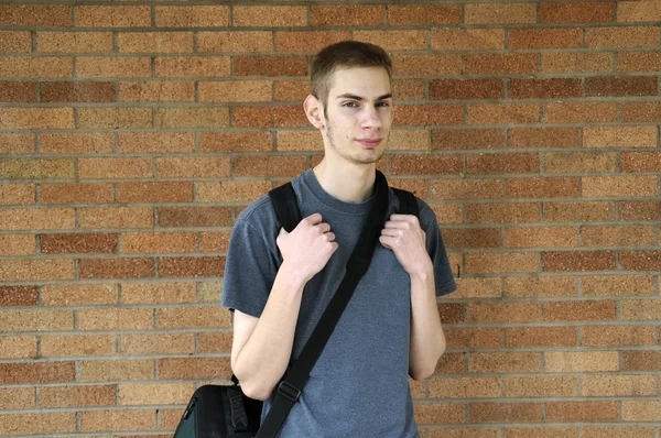 Молодой Белый Мужчина Смотрит Камеру Рюкзаком Стене — стоковое фото