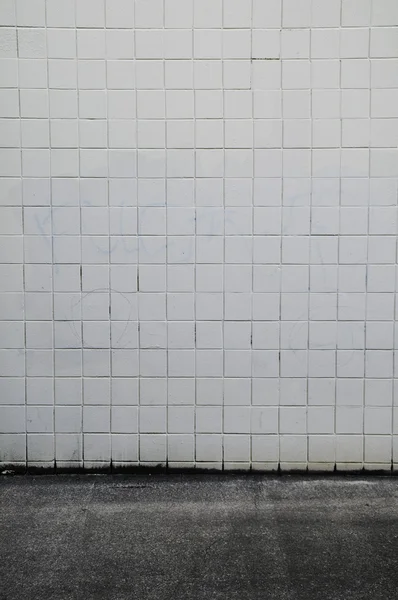 Asfalt zemin ile döşeli çimento duvar — Stok fotoğraf