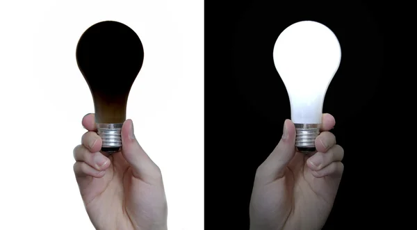 白い背景上に分離されて黒電球と 黒い背景に分離した正規ホワイト電球を保持する手 — ストック写真
