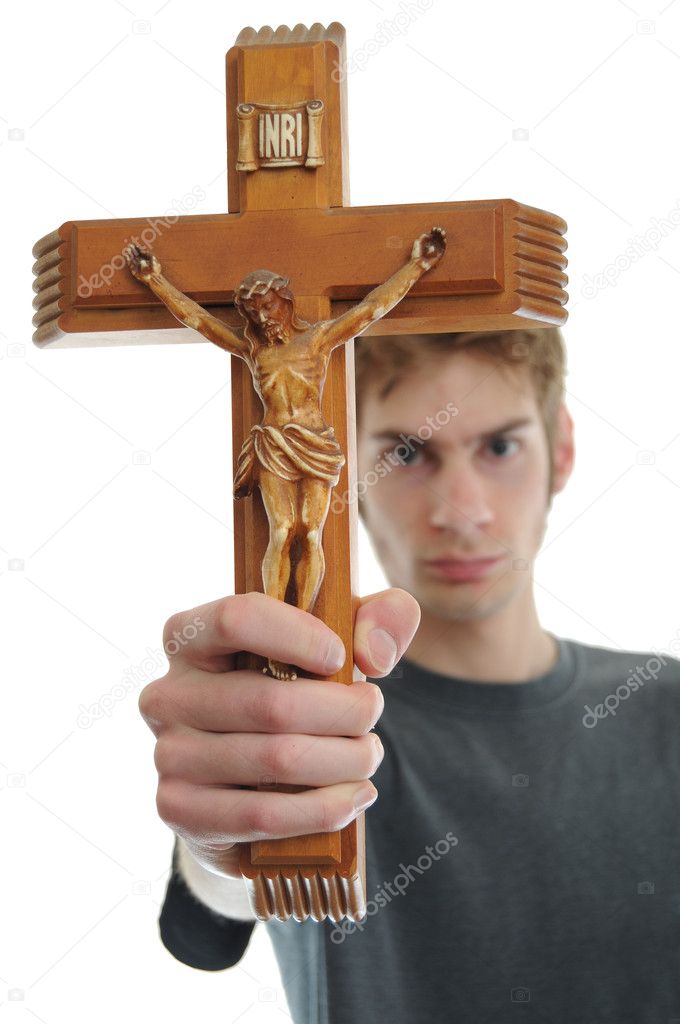 Young man holds up a wooden crucifix of Jesus. Isolated on white.