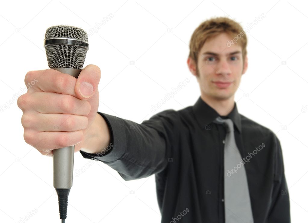 Young man smiles and holds up microphone on white