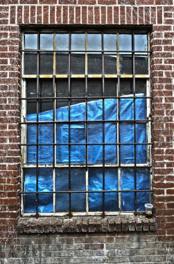 Bu abonded tuğla binaya kırma önlemek için koruyucu metal çubukları ile bir pencere.