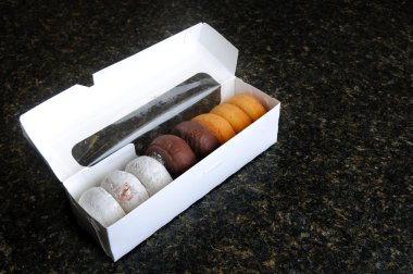 bir tezgah üzerinde beyaz bir kutu içinde çeşitli donut çeşitleri.