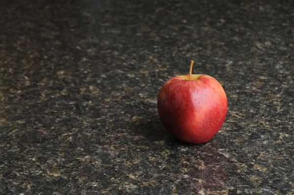 Red Apple on Black Kitchen Countertop — Stock Photo, Image
