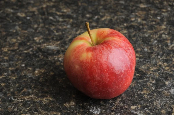 Red Apple on Black Kitchen Countertop — Stock Photo, Image
