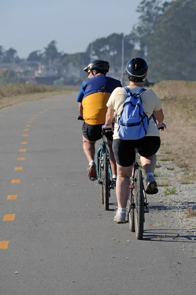 stock image Two Bicyclists riding on a narrow road.