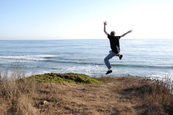Uma Pessoa Saltando Penhasco Com Mar Praia Oceano Abaixo Dele — Fotografia de Stock