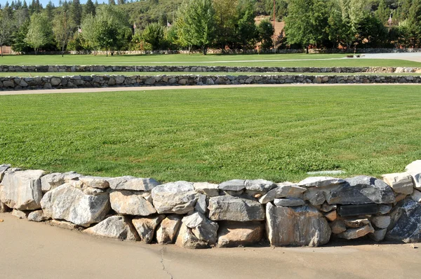 草と日中の岩壁で近代的な円形競技場 — ストック写真