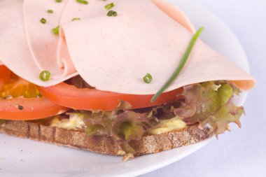 Mischbrot belegt mit Mortadella und Schnittlauch clipart