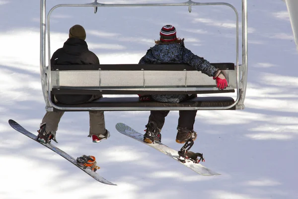 Snowboarders on a ski lift — Stock Photo, Image