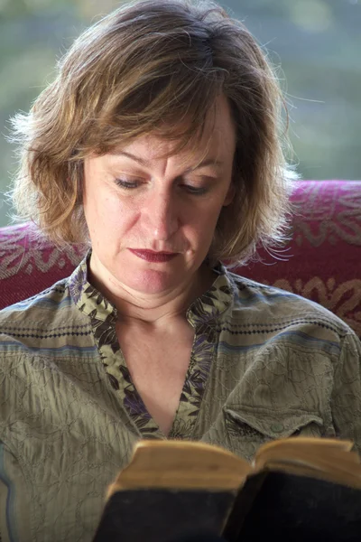 Close up of woman reading book with back lighting — Stock Photo, Image