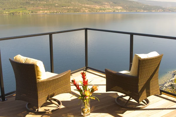 stock image Two luxurious chairs on a sundeck on a lakefront home in beautiful dusk lighting