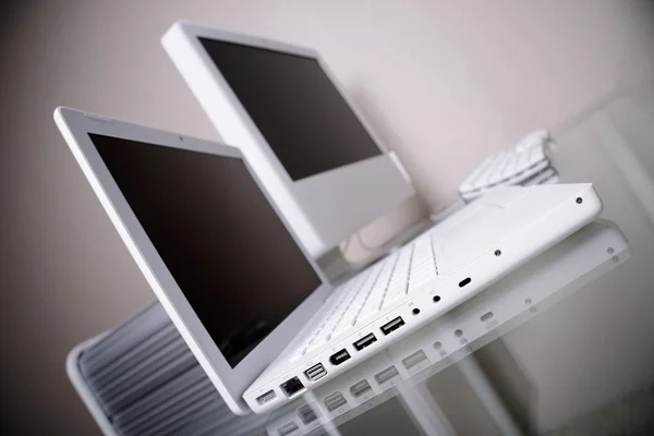 近代的な優雅さ白いラップトップとガラスの机の上のコンピューター — ストック写真
