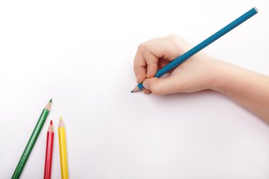 Child hand draws a blue pencil. White-gray background Above view.