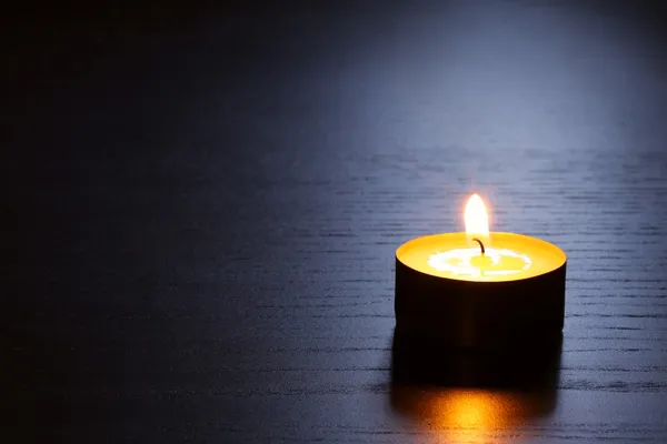 黑暗的木桌上的蜡烛背光 近摄镜头具有选择性焦点 图库照片