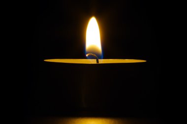 Candle flame. Single candle on black background. clipart