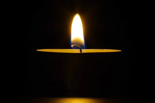 ろうそくの炎 黒の背景上の単一の蝋燭 — ストック写真