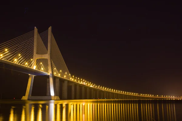夜のリスボン テージョ川川にバスコ ガマ橋します — ストック写真