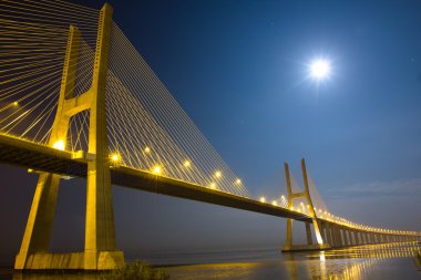 Long Vasco da Gama bridge at night under moonlight clipart