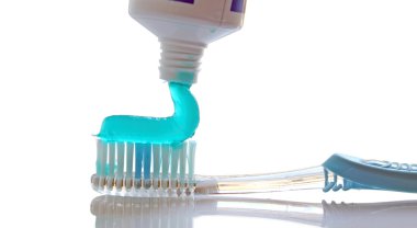 Closeup of toothpaste coming out of a tube on white clipart