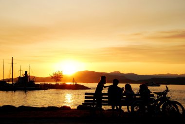 Silhouette of happy family enjoy beautiful sunset view in English Bay clipart