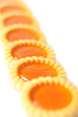 Beyaz arkaplanda turuncu reçelli kurabiyeler