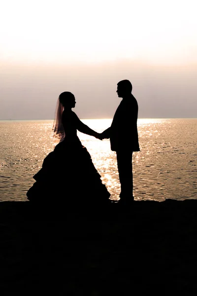 Bruid en bruidegom bij zonsondergang — Stockfoto