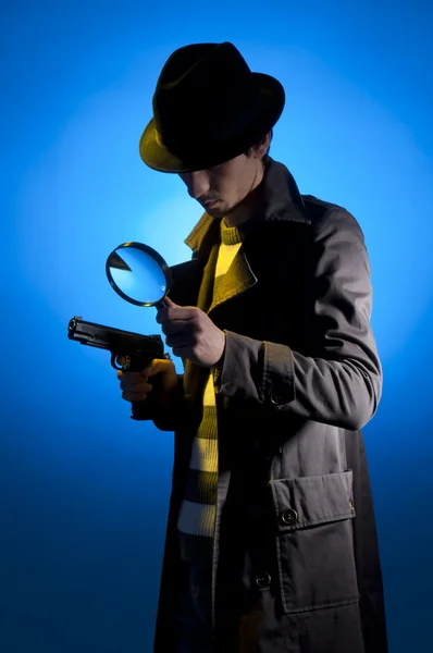 用小相机 拍摄在蓝色背景 黄色光和黑烟的工作室拍照的私家侦探 — 图库照片