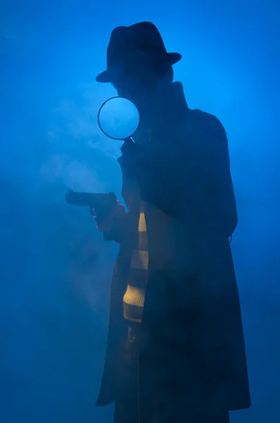 用小相机 拍摄在蓝色背景 黄色光和黑烟的工作室拍照的私家侦探 — 图库照片
