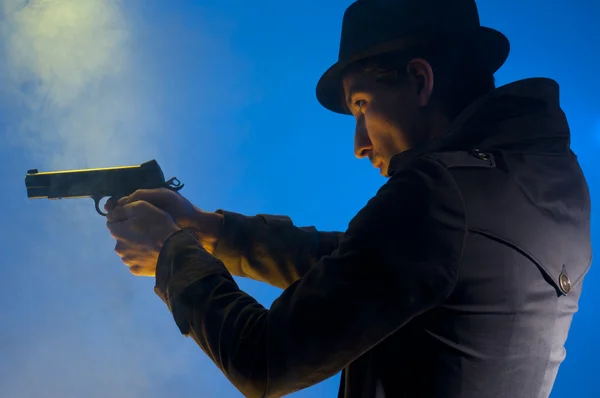 Hombre Sosteniendo Una Pistola Disparado Estudio Sobre Fondo Azul Con — Foto de Stock