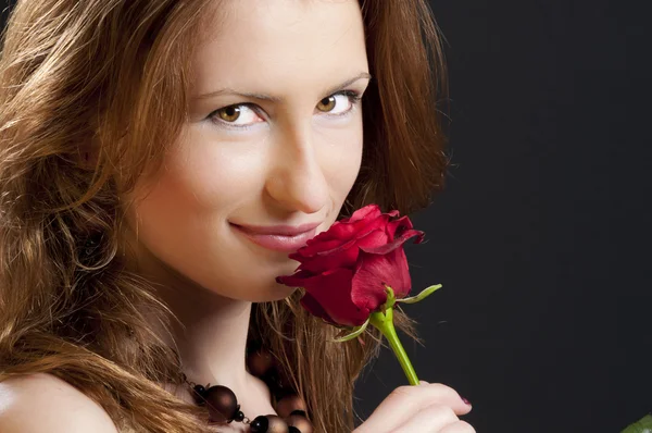 年轻女孩玩红玫瑰收到情人节那天在黑色背景上孤立 — 图库照片