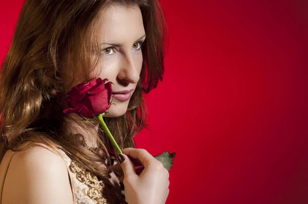 年轻女孩玩红玫瑰收到情人节红色背景上孤立 — 图库照片