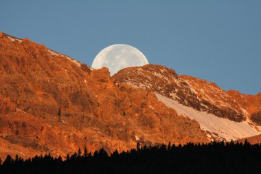 Dolunay arkasında dağ manzaralı Alberta