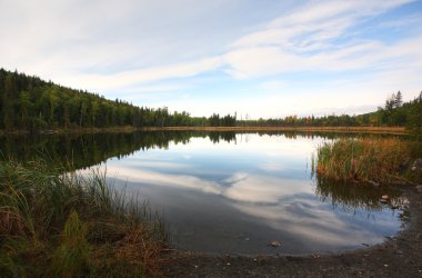 Reflections on a mountain lake in British Columbia clipart