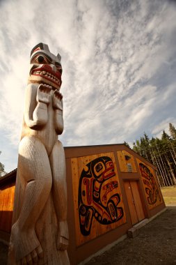 Totem pole outside native lodge at Kitsumkalum Provincial Park clipart