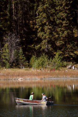 Two women boating on Ressor Lake in Alberta clipart