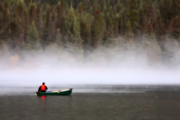 Ember a kajak-kenu közelében reggeli köd-tó — Stock Fotó