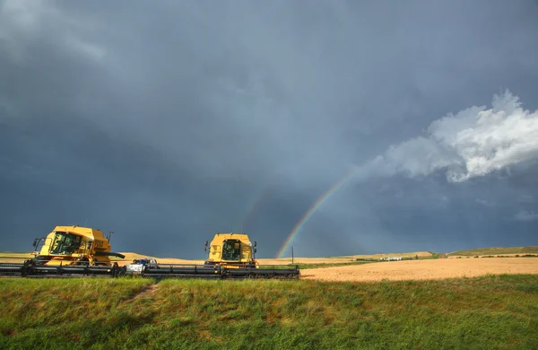 Rainbow behind parked combine in Saskatchewan — Stock Photo, Image