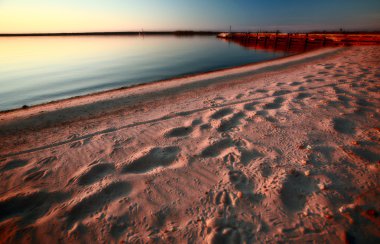 Beach and dock along shore of Lake Winnipeg clipart