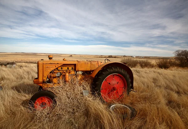 Tumbleweeds piled against abandoned tractor — Stock Photo, Image
